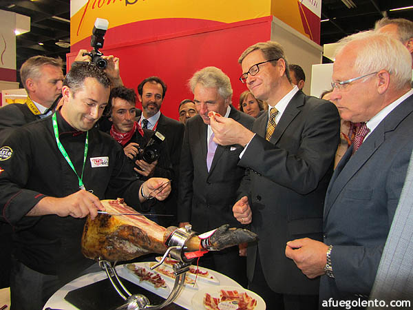 El ministro alemán de Exteriores, Guido Westerwelle, probando jamón durante la feria